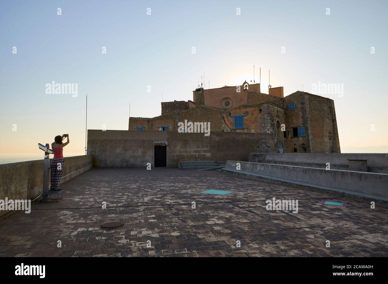 Female photographer at sunset at the rooftop of Sant Salvador gothic monastery at Sant Salvador Sanctuary (Felanitx, Majorca, Balearic Islands, Spain) Stock Photo