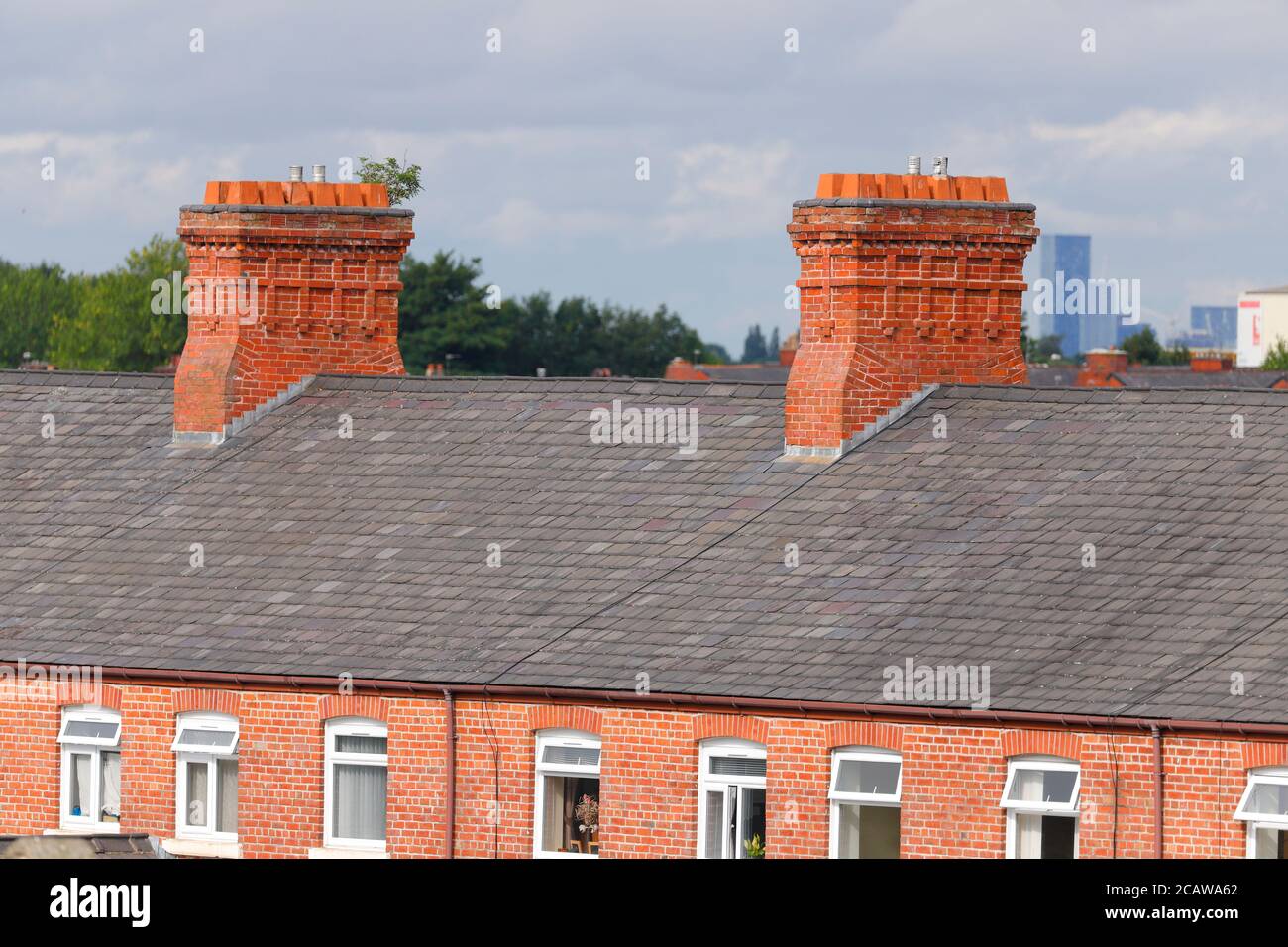 Red brick chimneys on rooftops in Ashton Under Lyne, Manchester. Stock Photo