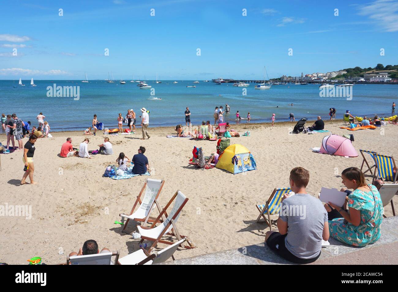 Visitors flock to the sandy beaches at Swanage making the best of the sunny weather, Dorset, UK Stock Photo