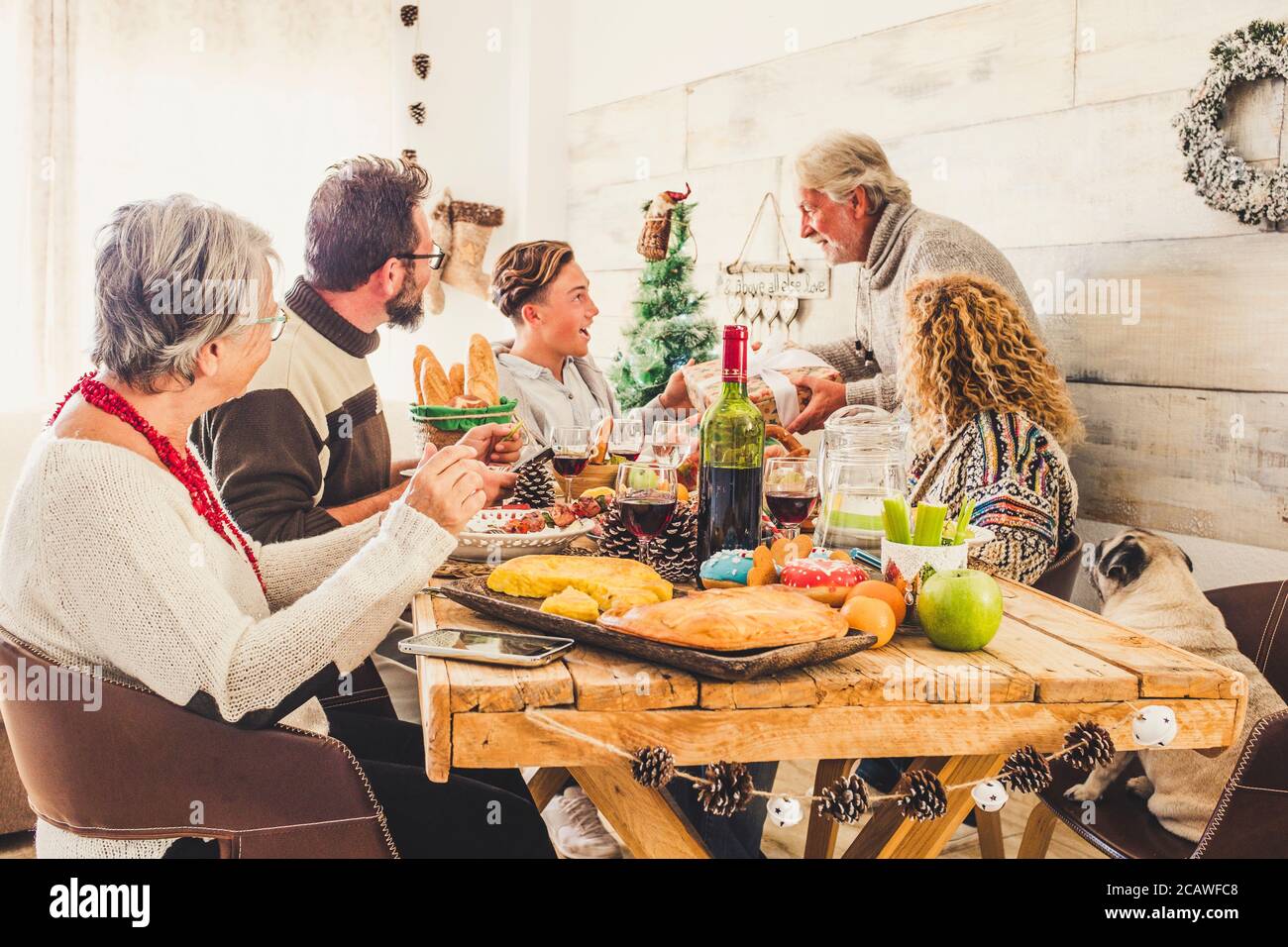 Family at home celebrate christmas eve lunch and give presents to each Christmas Eve Traditiona