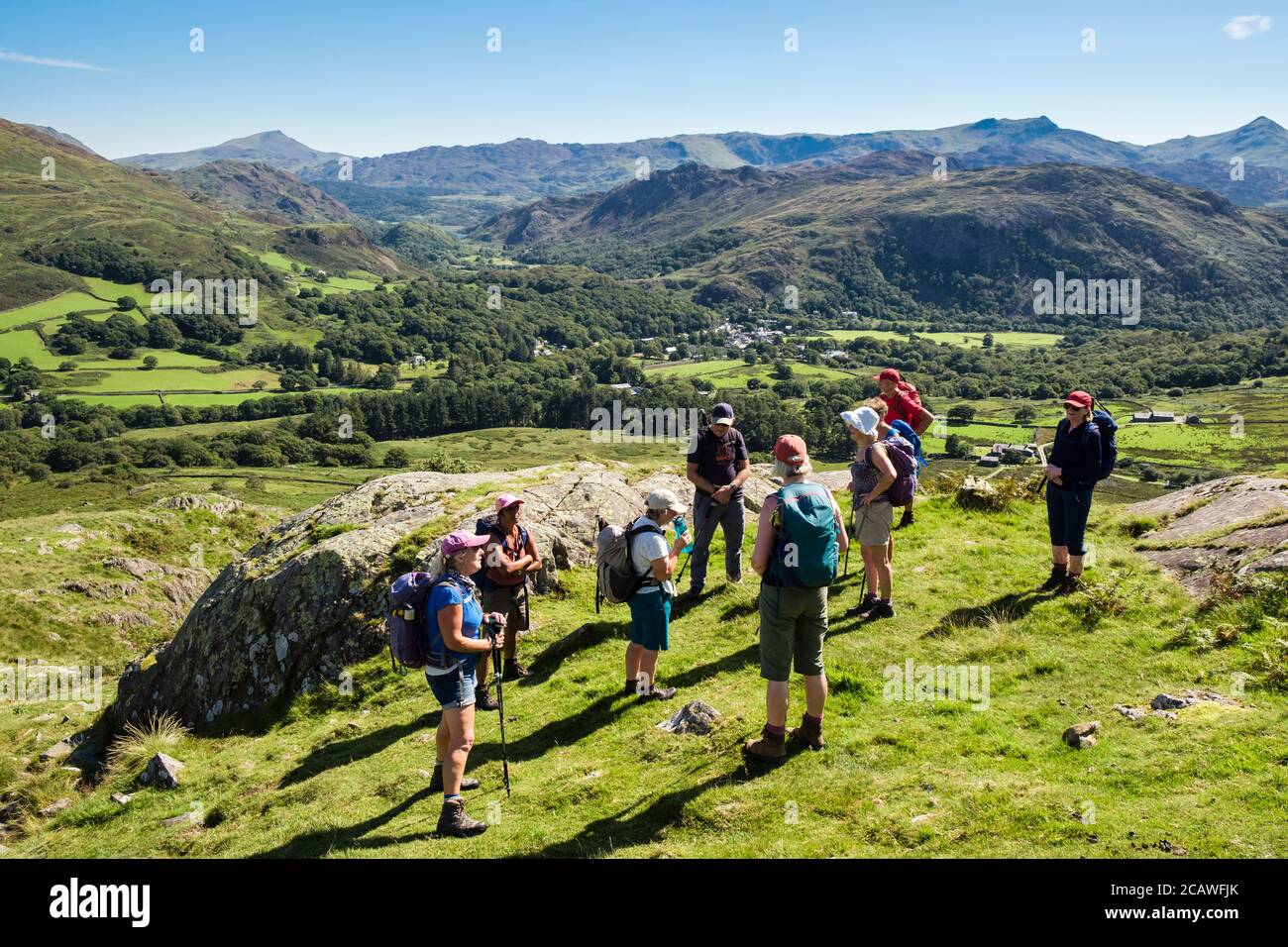 Hikers resting on Moel Hebog with view to mountains in Snowdonia National Park. Beddgelert, Gwynedd, Wales, UK, Britain Stock Photo