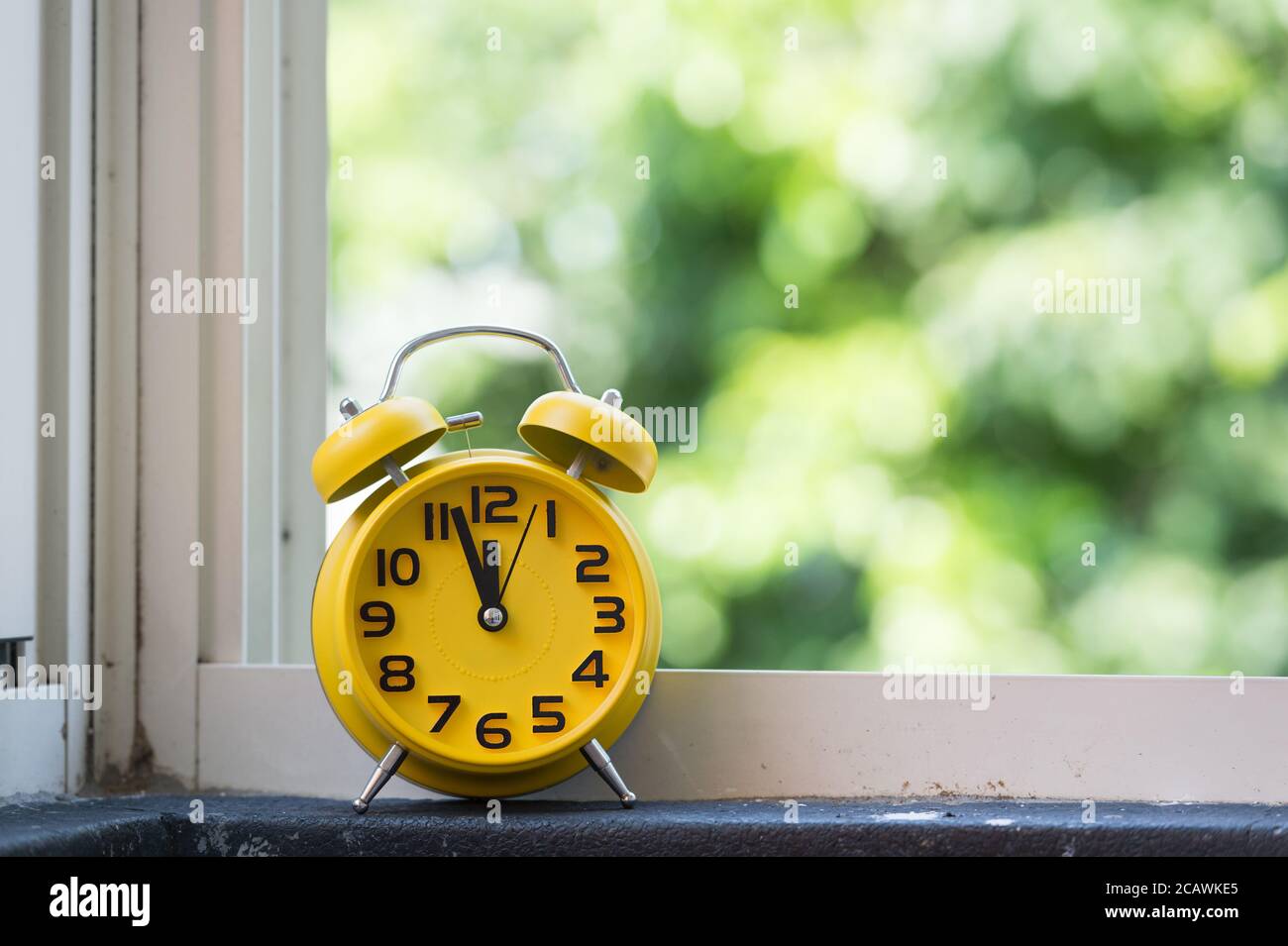 Retro alarm clock with five minutes to twelve o'clock Stock Photo Alamy