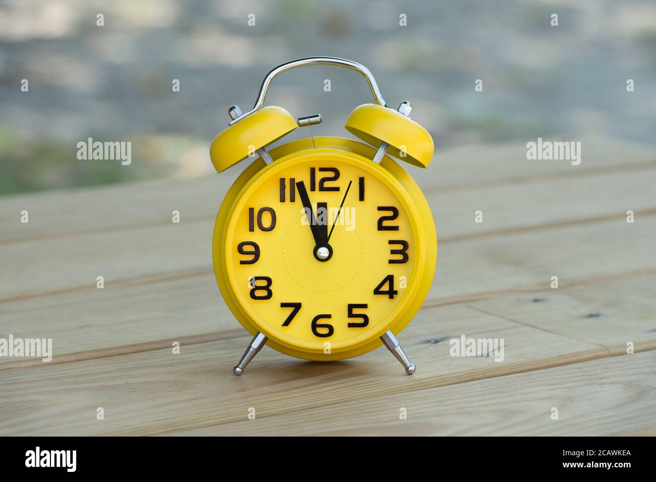 Retro alarm clock with five minutes to twelve o'clock Stock Photo Alamy