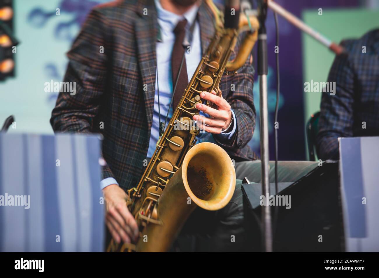 Concert view of a saxophonist, saxophone sax player with vocalist and  musical during jazz orchestra performing music on stage Stock Photo - Alamy