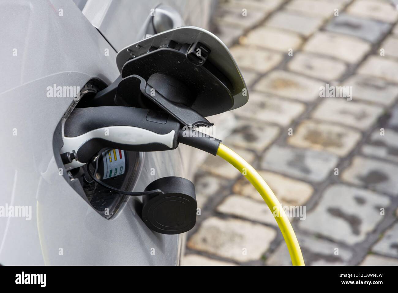 Recharging of an an electric car with a plug and cable Stock Photo