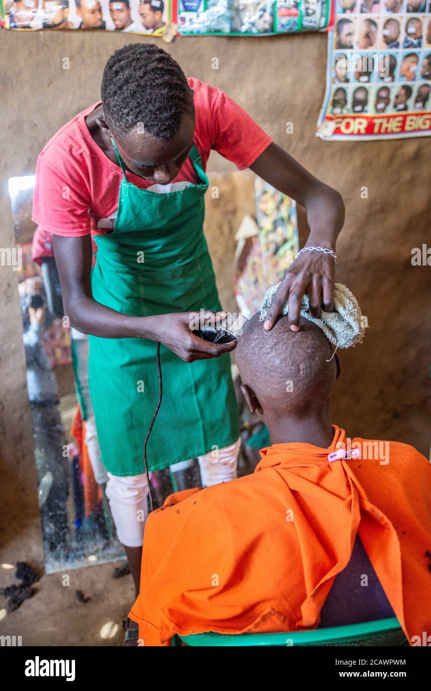 A young man having his hair cut at a rural barbershop, Moroto District,  Uganda Stock Photo - Alamy