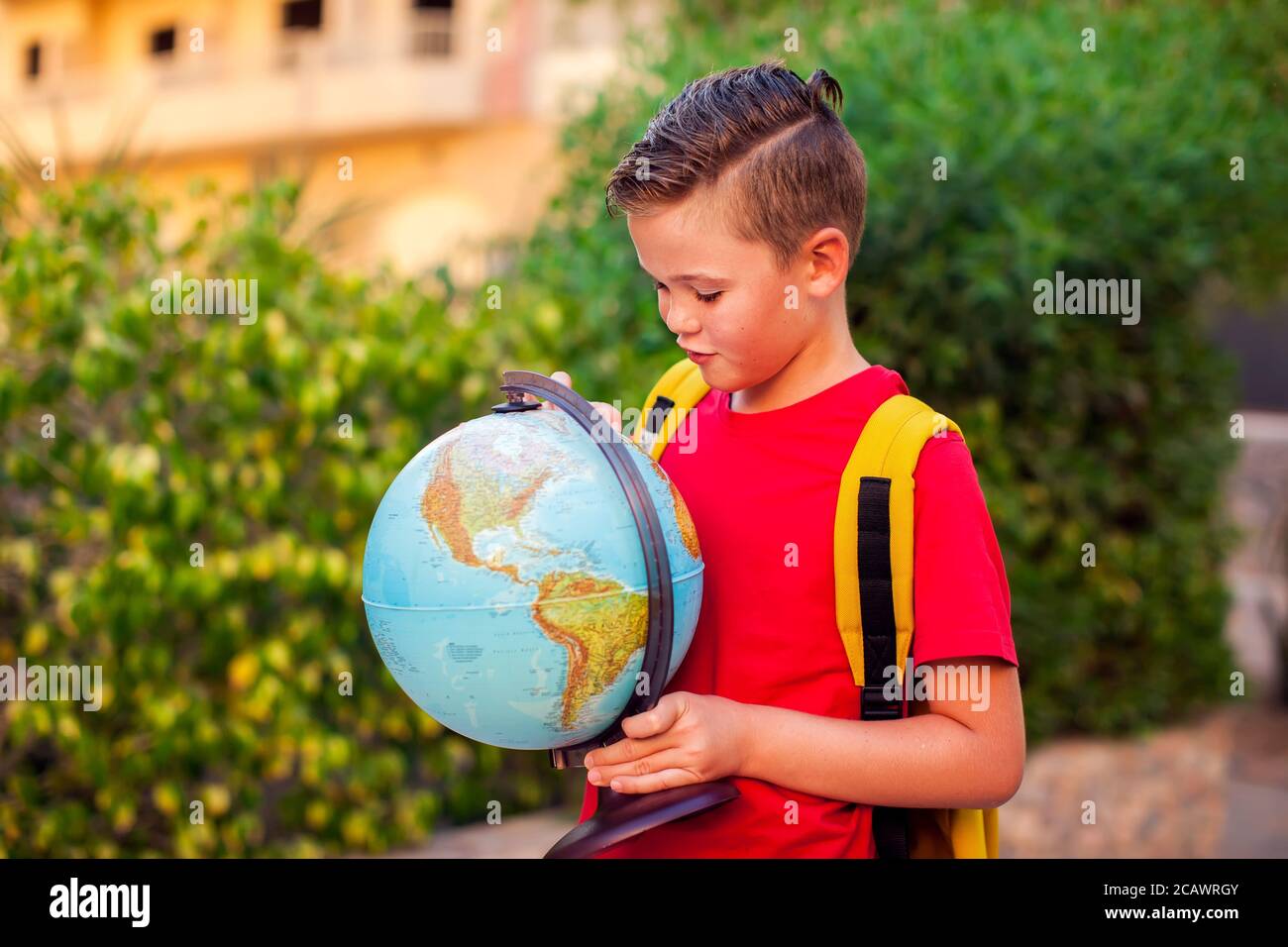Back to school. Pupil keeping globe outdoor. Geography and education concept Stock Photo
