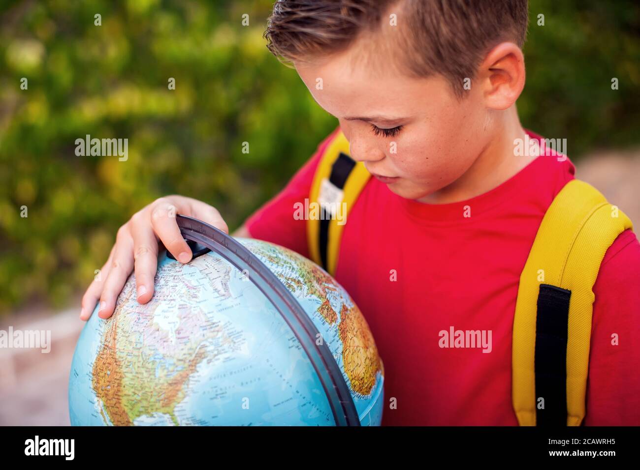 Back to school. Pupil keeping globe outdoor. Geography and education concept Stock Photo