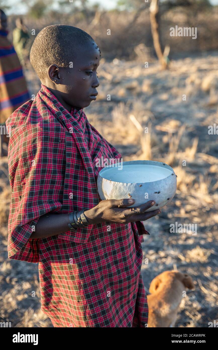 A young Karamojong herder holding a milk jug, Moroto District, Uganda Stock Photo