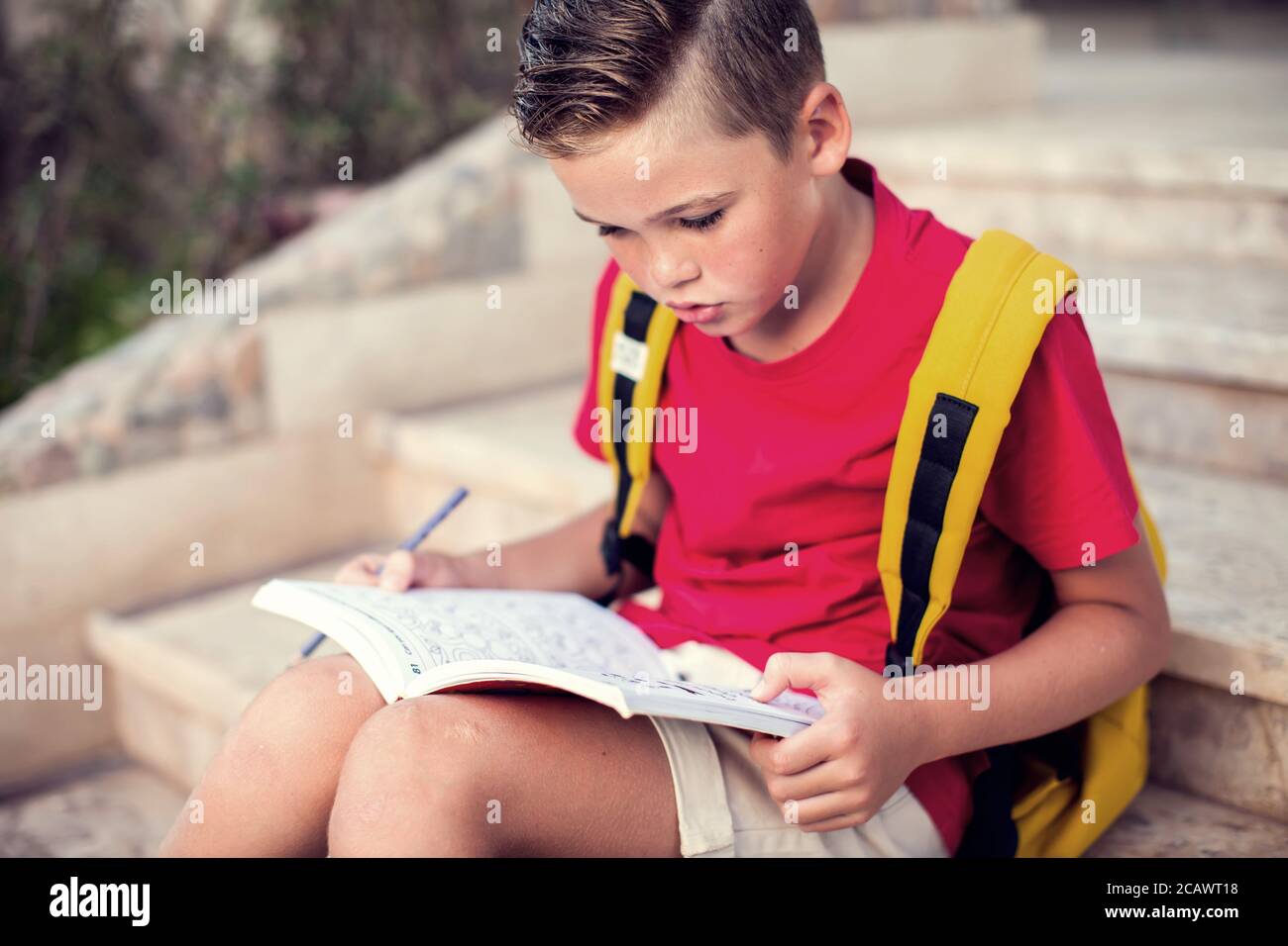 Back to school. Pupil reading book outdoor. Childhood and knowledge concept Stock Photo