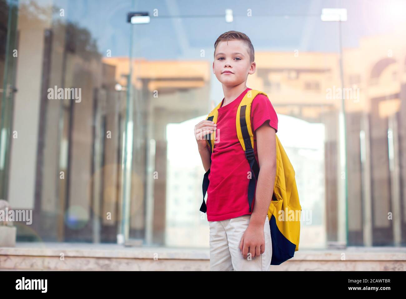 Back to school. Pupil boy with backpack staying outdoor Stock Photo