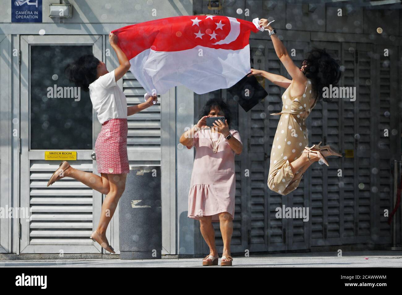 Singapore. 9th Aug, 2020. Two women have a photo taken with Singapore's national flag during the National Day celebrations at the Merlion Park in Singapore, Aug. 9, 2020. Singapore celebrated its 55th National Day on Sunday. Credit: Then Chih Wey/Xinhua/Alamy Live News Stock Photo