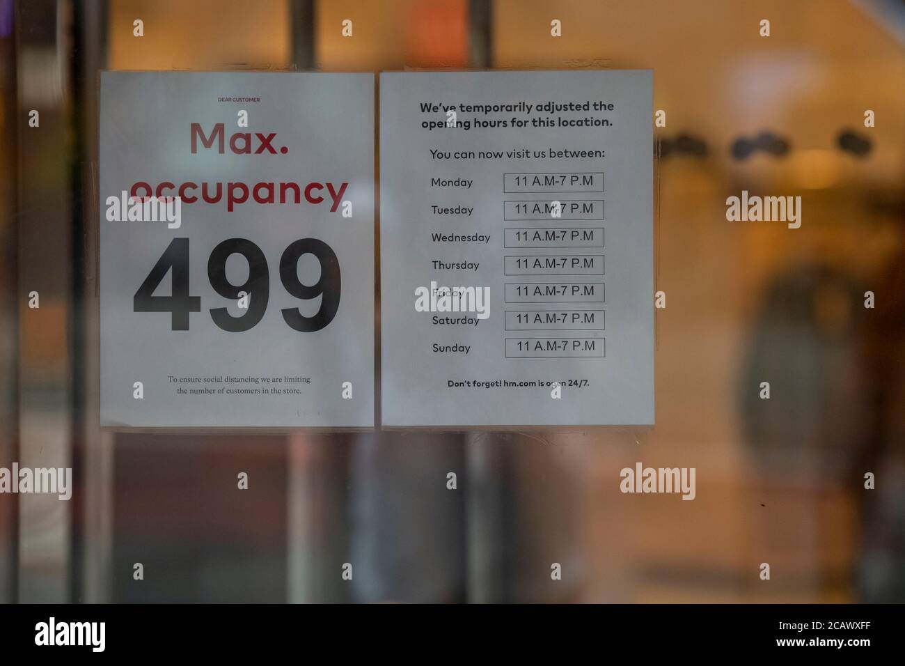 August 08, 2020: A maximum occupancy sign sits on the front doors of H&M in  Times