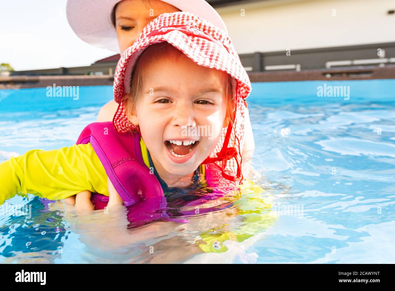 23 years old child with mother in swimming pool learn to swim. Summer