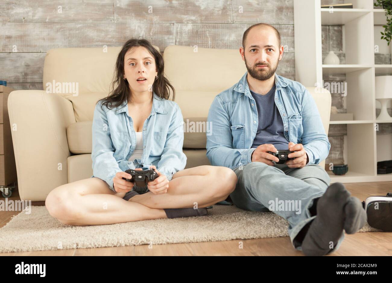 Young couple relaxing playing video games with wireless controller
