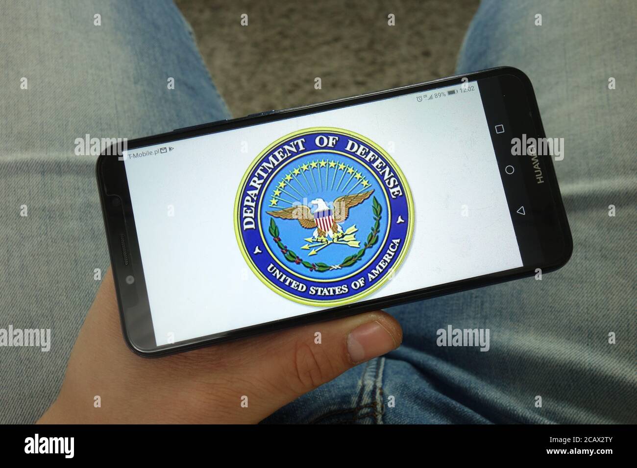 Man holding smartphone with United States Department of Defense logo Stock Photo