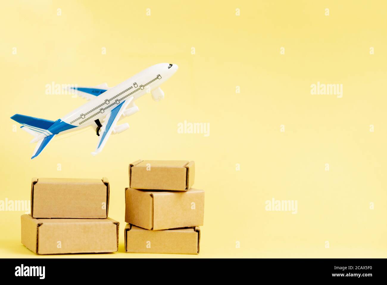 Airplane and stack of cardboard boxes. concept of air cargo and parcels, airmail. Fast delivery of goods and products. Cargo aircraft. Logistics Stock Photo