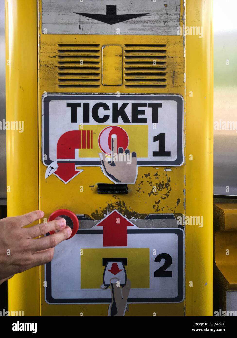 Hand pushing red button for a ticket at Italian highway - autostrade toll booth Stock Photo