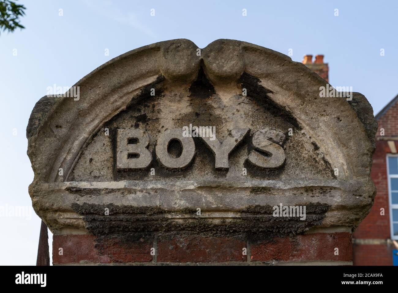 A brick pillar outside a school with the words Boys a common sight on the entrance to a school in the Victorian era when children were segregated Stock Photo