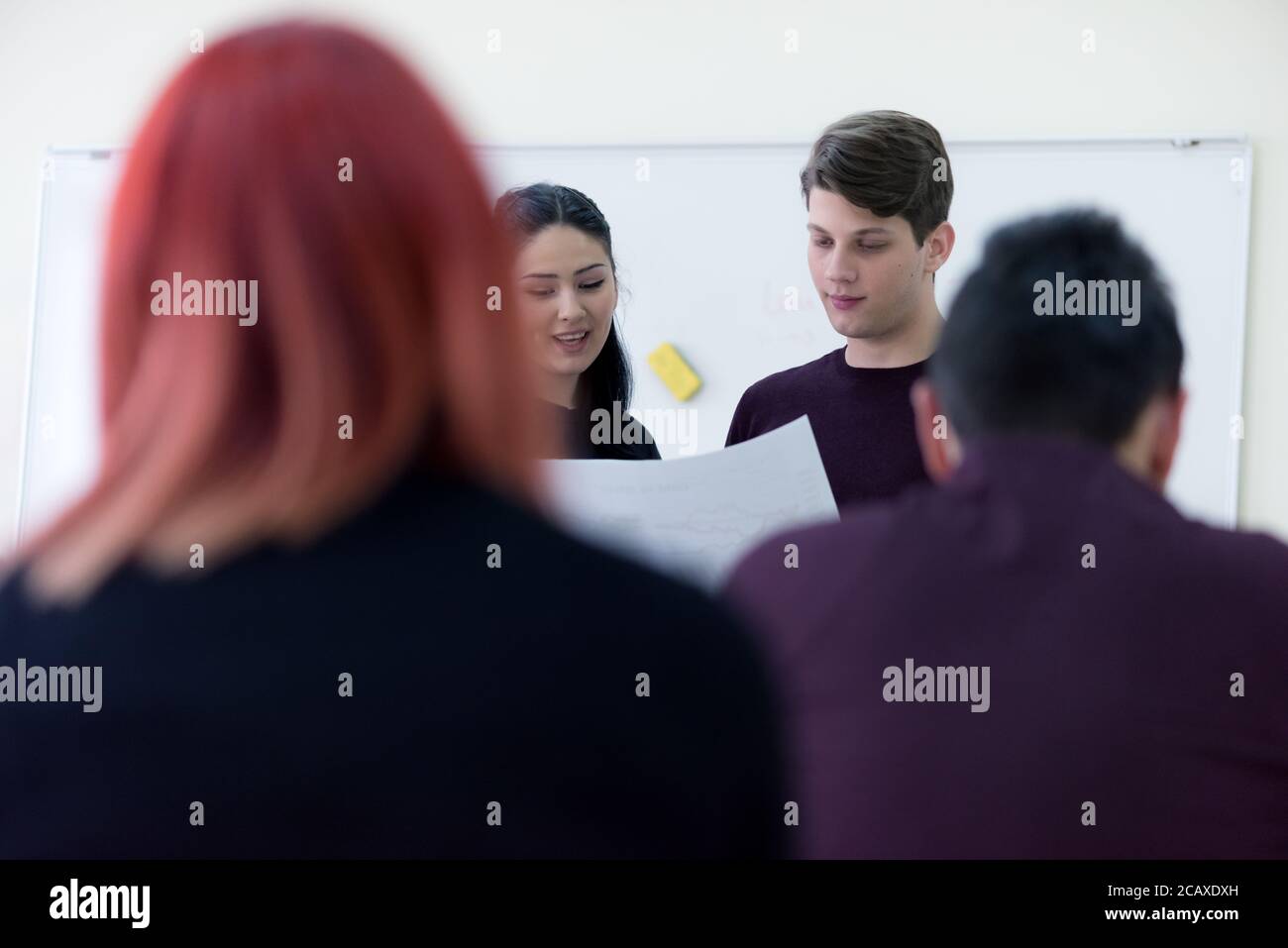 Exams Preparation. Group Of Multi-Ethnic Students Studying Together inside classroom while helping each other. Stock Photo