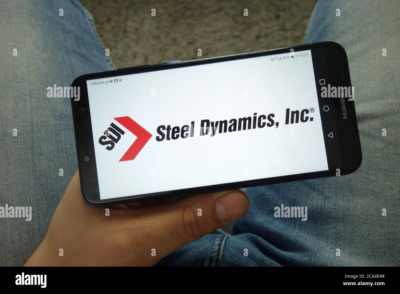 Man holding smartphone with Steel Dynamics, Inc. logo Stock Photo Alamy