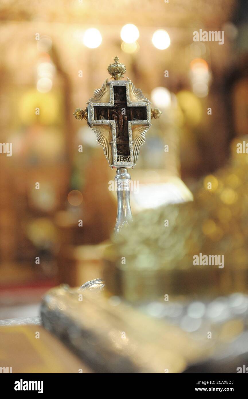 Beautiful silver cross encapsulating an old wooden sculpture of Jesus on the cross, embellished with golden features in a Romanian church Stock Photo