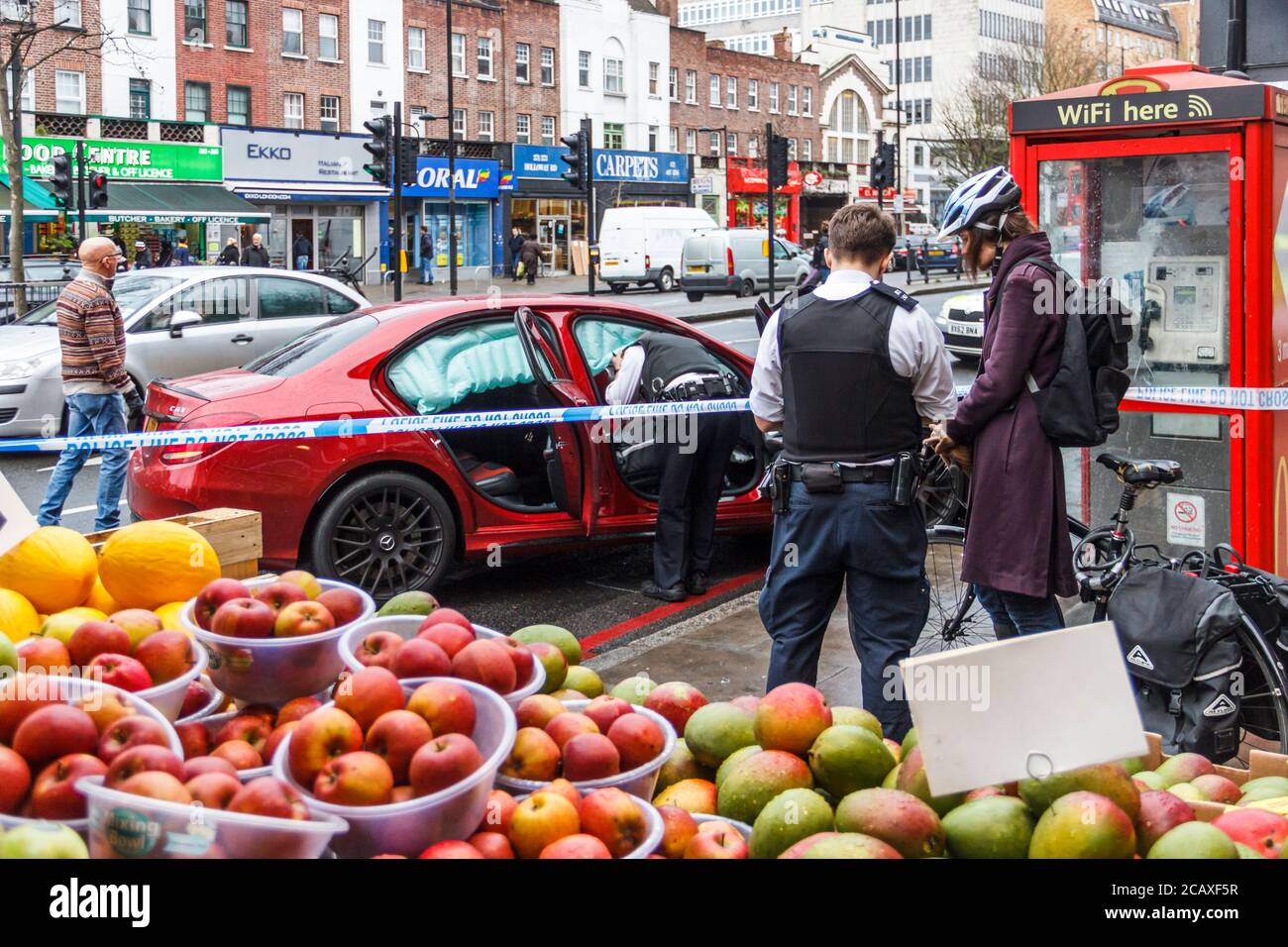 Police officer interviewing a witness to a road traffic incident involving a car in Holloway Road, London, UK in January 2016. Luckily no one was hurt Stock Photo
