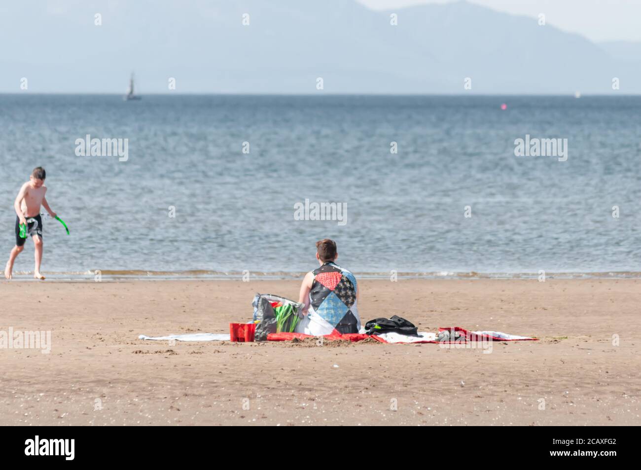 Barassie Beach Troon Scotland Uk 9th August 2020 Uk Weather A Woman Sitting On Barassie Beach With The Isle Of Arran On The Horizon Credit Skully Alamy Live News Stock Photo Alamy