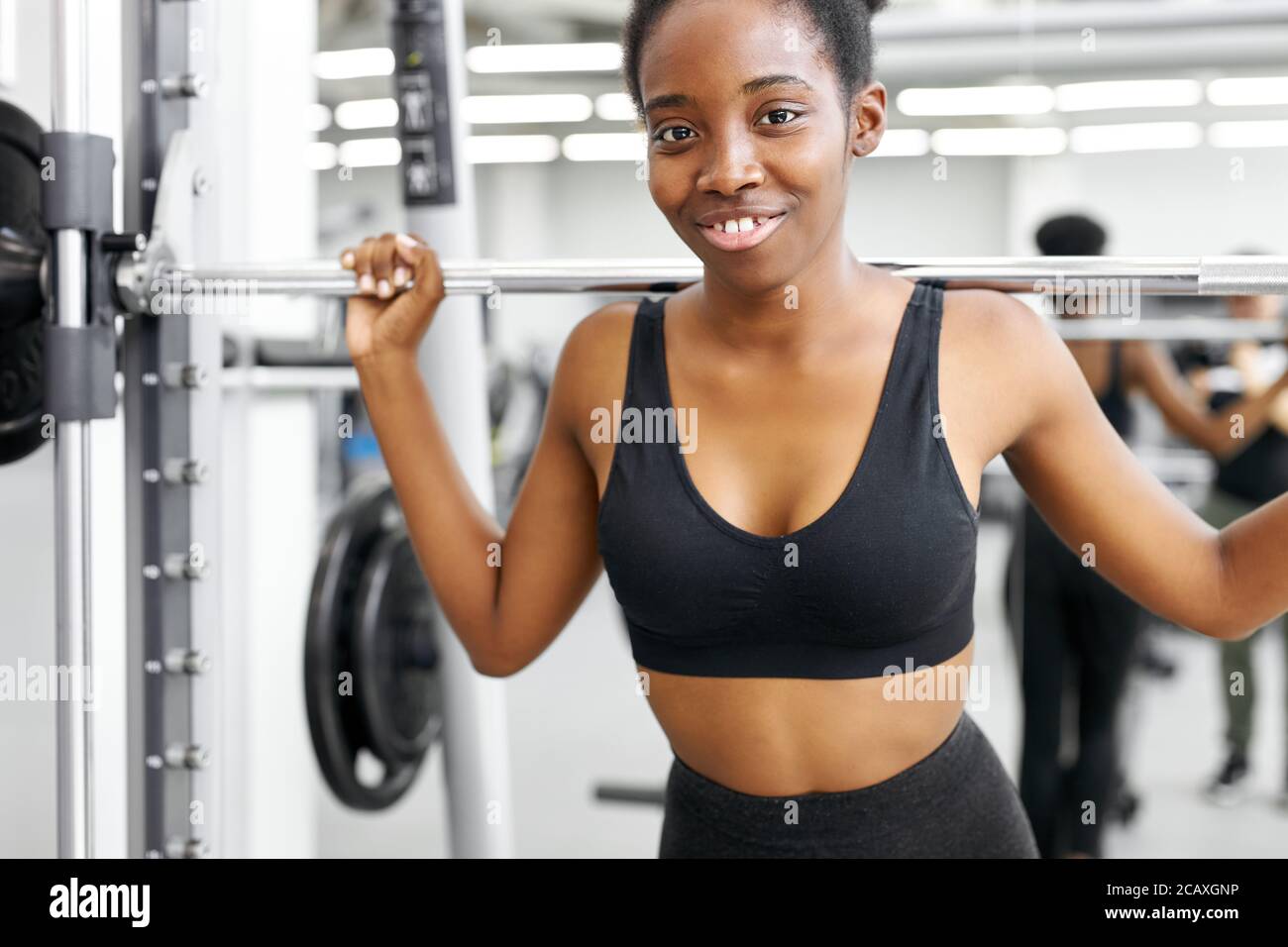 Athletic Woman Pumping Up Muscules with Dumbbells Stock Photo