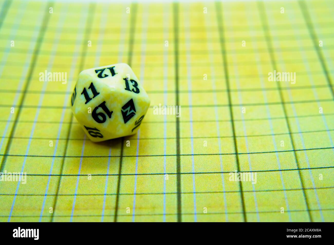 Yellow role-playing board with white dice on top Stock Photo