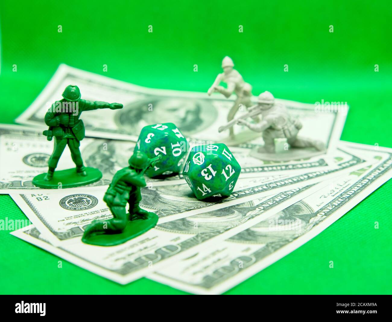 Dice of roleplaying and figures of soldiers on top of hundred dollar