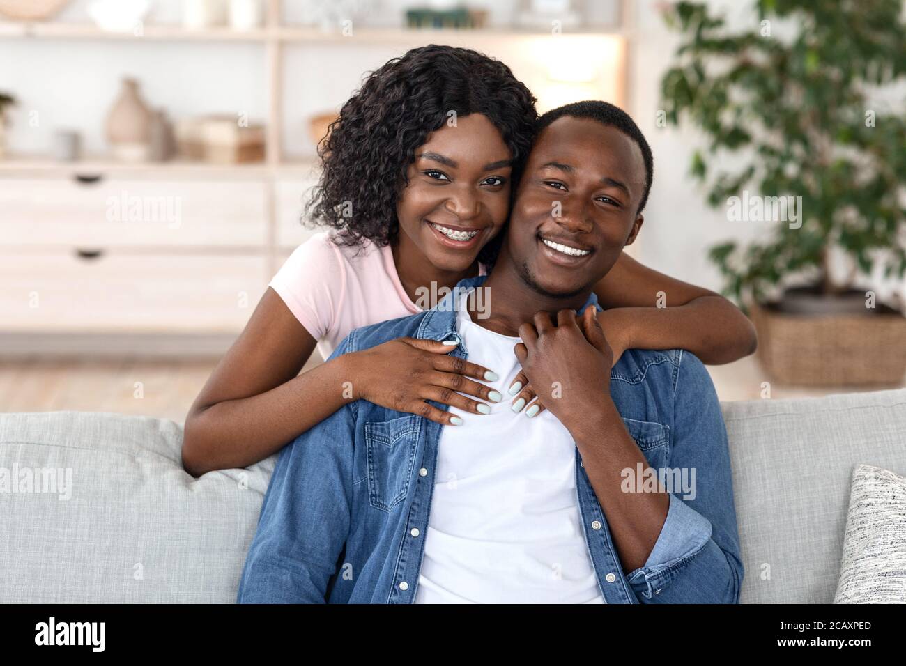 Cheerful african woman hugging her husband from behind Stock Photo - Alamy