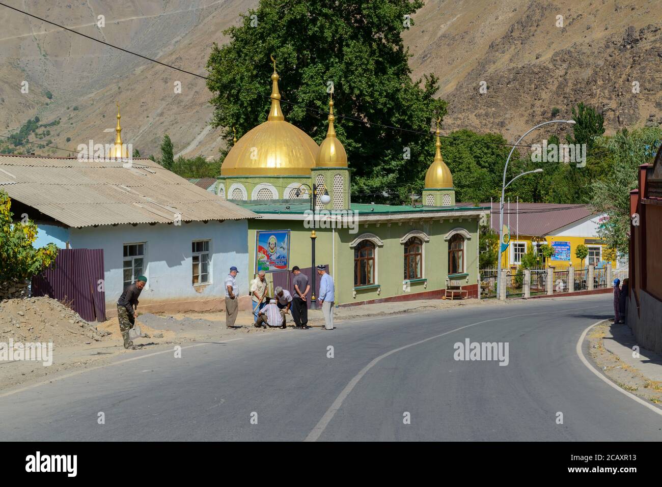 Men at work on the street near the mosque in Qal'ai Khumb, Tajikistan Stock Photo