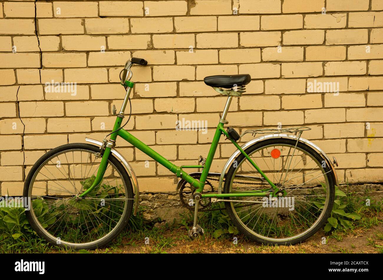 Green old retro Russian folding bicycle on a background of white bricks,  women Stock Photo - Alamy