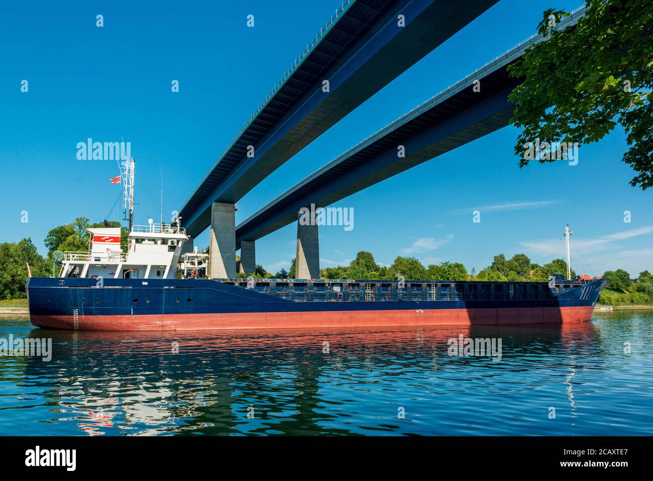 Reger Schiffsverkehr im Nord-Ostsee-Kanal einem der meistbefahrenen künstlichen Wasserstraßen der Welt, hier unter der Holtenauer Hochbrücke Stock Photo