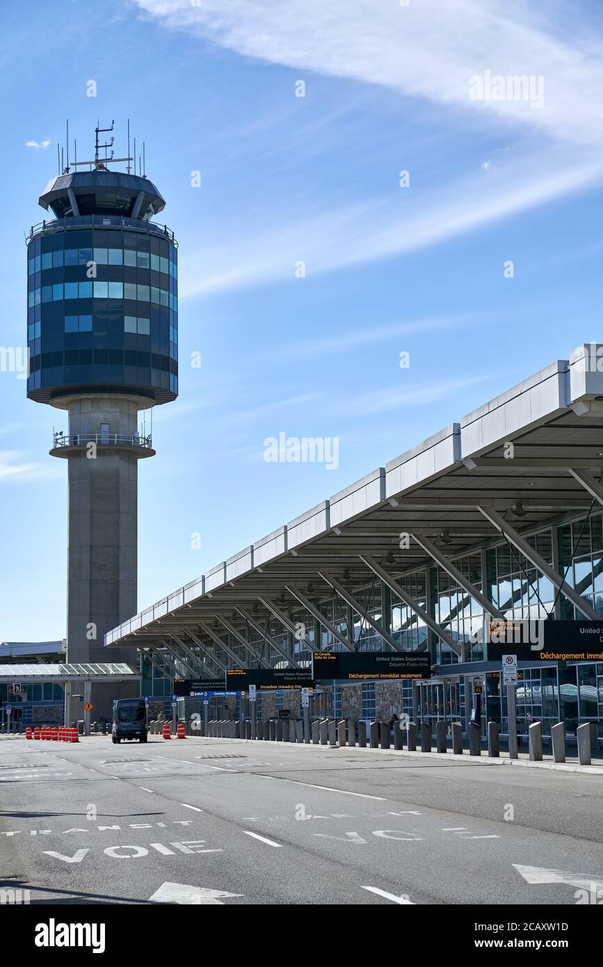 Vancouver International Airport YVR international departures terminal drop-off area, with Control Tower in background, facing West, during COVID-19 Stock Photo