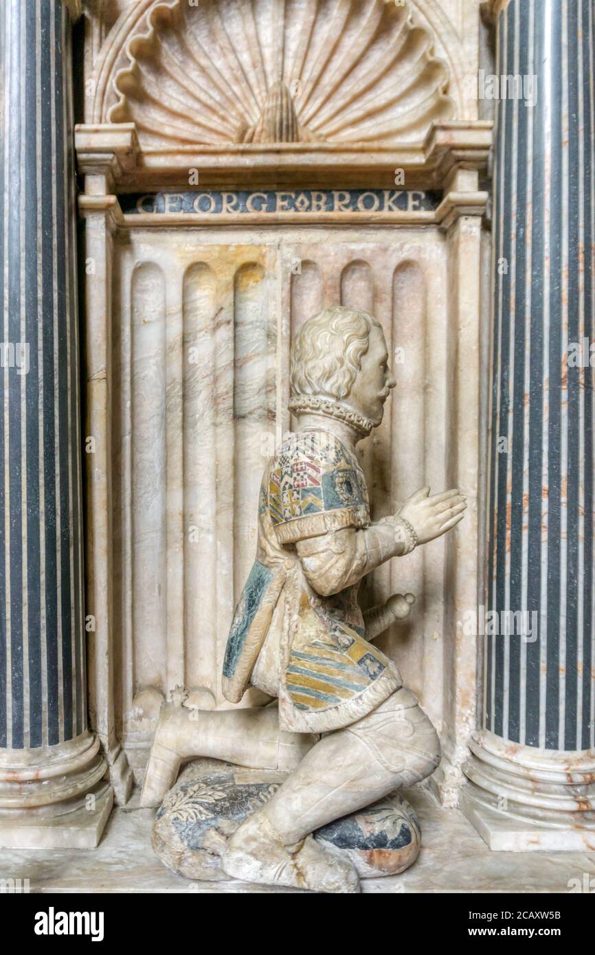Carved mourner beside the 16th century tomb of the 9th Lord Cobham, Sir George Brooke, & his wife in St Mary's church, Cobham, Kent. Shows son George. Stock Photo