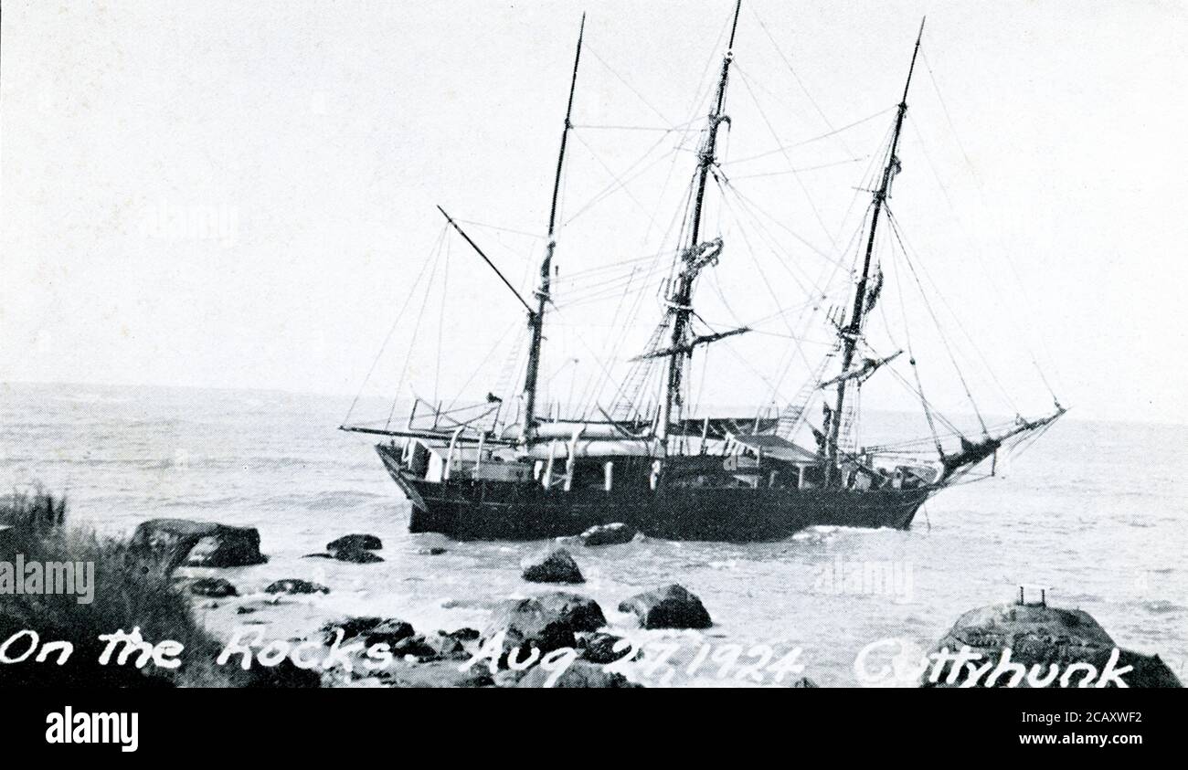 This photo shows the whaler named Wanderer on the rocks on August 27, 1924. The whaler was caught in a storm on August 26, grounded off the island of Cuttyhunk,  and had to be abandoned - the last voyage of the ship and the last whaler to leave the port of New Bedford, Massachusetts, a city that had once been the whaling capital of the world. The Wanderer was featured in the movie Down to the Sea in Ships. Stock Photo