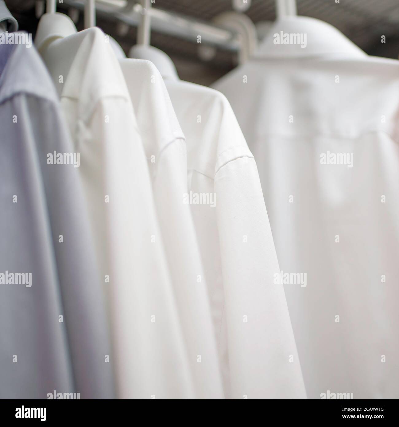 white men's shirts on hangers in wardrobe Stock Photo Alamy