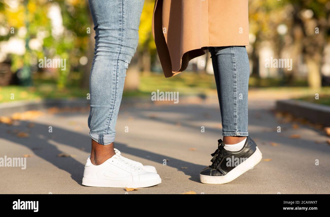 Romantic afro couple standing and kissing on path in city park Stock Photo