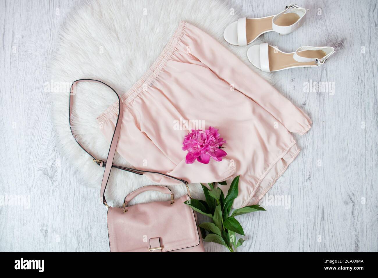 Pink blouse, bag, shoes and a peonie. Fashionable concept, white fur on the background Stock Photo