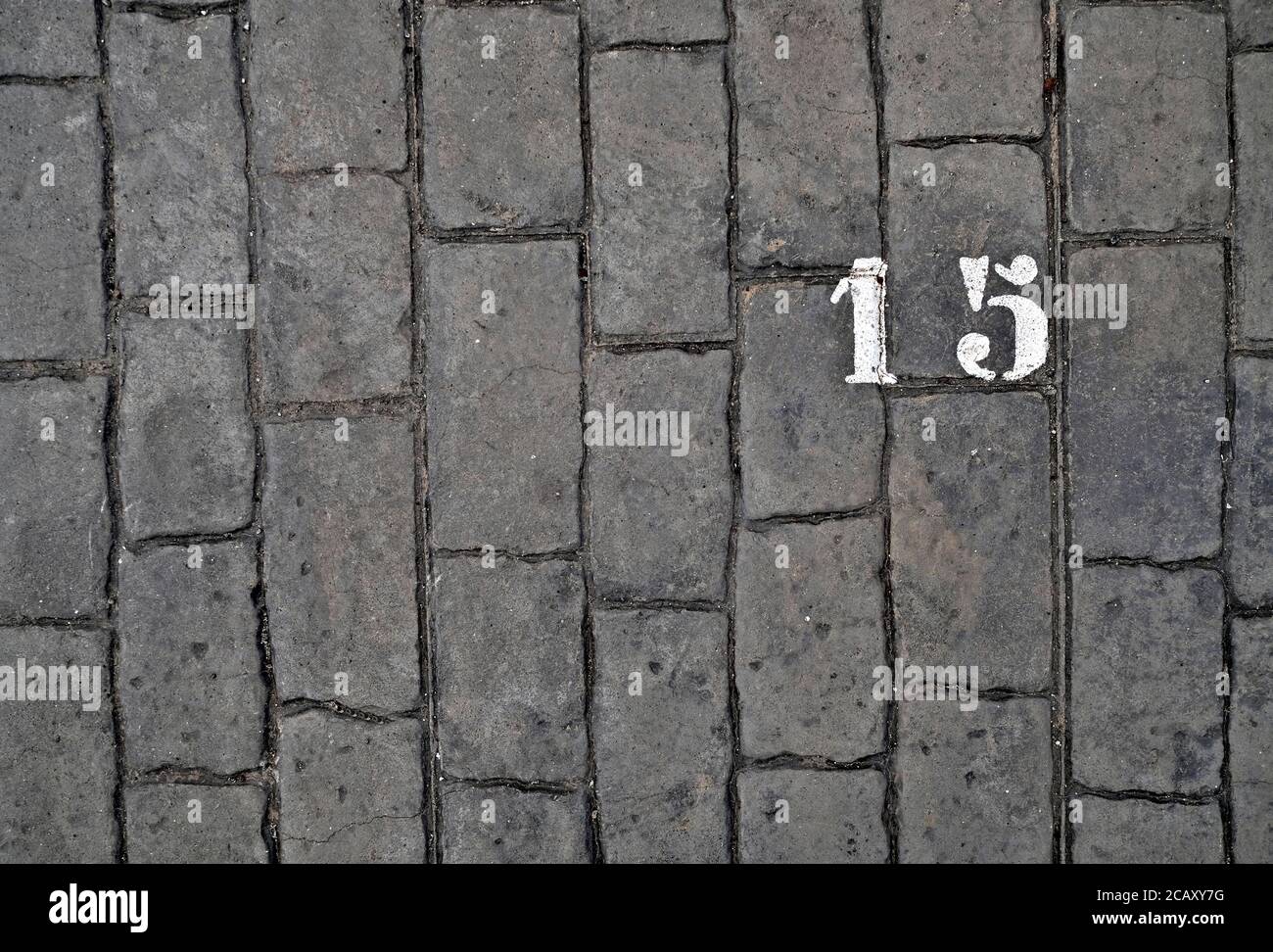 15, number fifteen, white stencil number on cobblestone surface. Stock Photo