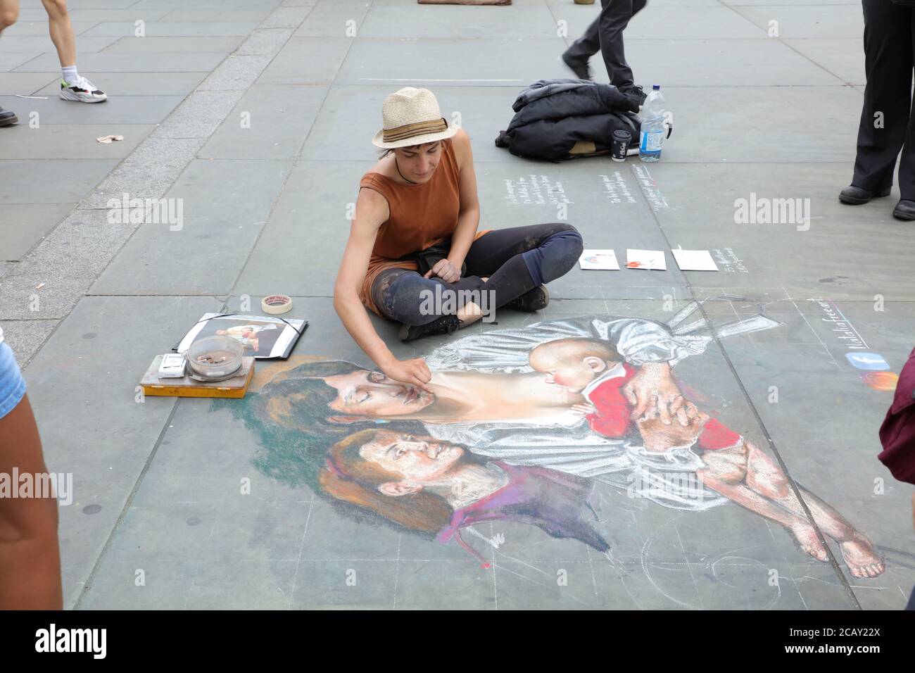 Woman busker seen drawing on the pavement of Trafalgar Square, with ...