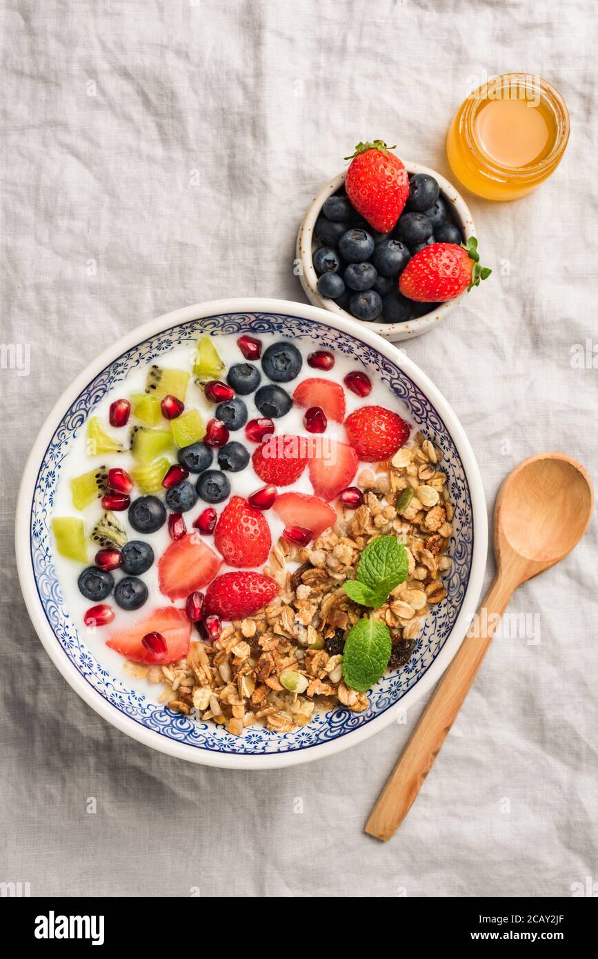 Granola bowl with berries, fruits and natural yogurt. Layered healthy breakfast cereal bowl. Top