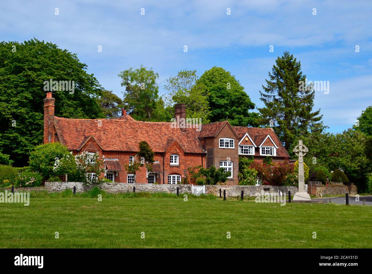 Old cottages beside the village green in Lee Common, Buckinghamshire, UK. The Chilterns, celtic cross monument. Stock Photo