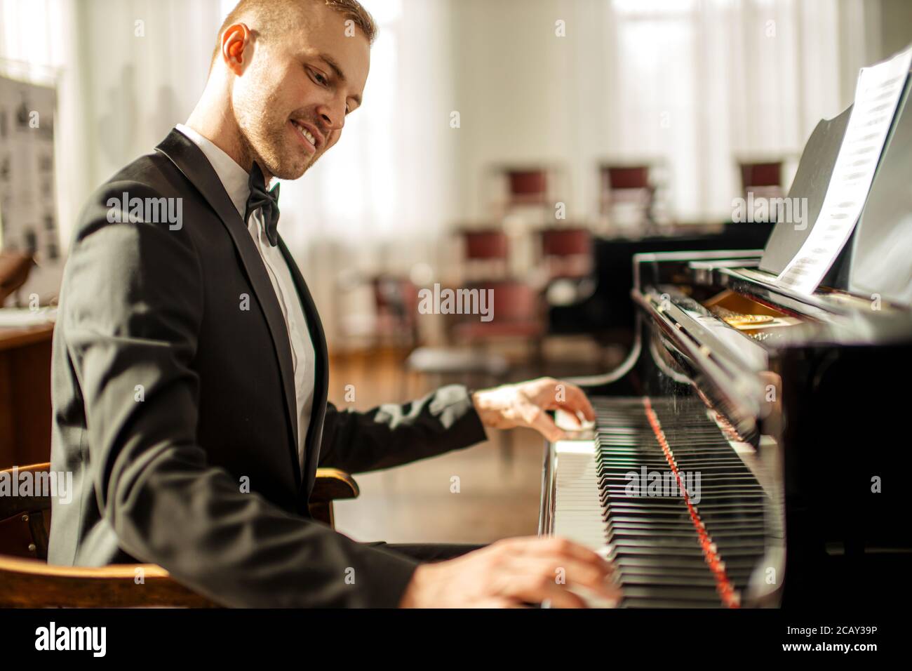 professional caucasian man musician gracefully play piano on a stage,  talented pianist in formal elegant suit perform music Stock Photo - Alamy