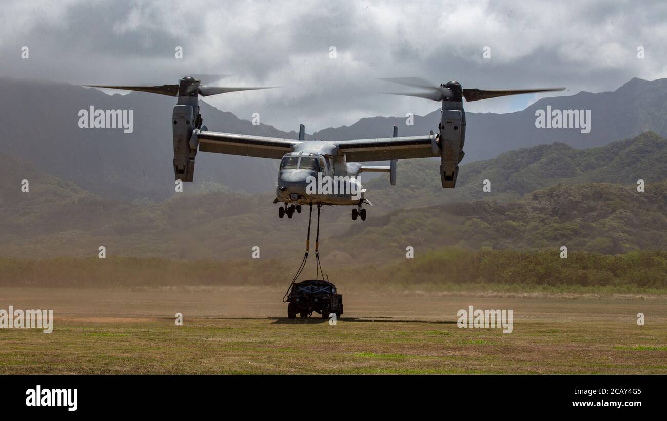 U.S. Marines with Marine Medium Tiltrotor Squadron 268 (VMM-268) hoist a Humvee belonging to Marine Unmanned Aerial Vehicle Squadron 3 (VMU-3) from Marine Corps Base Hawaii to Marine Corps Training Area Bellows for an aerial insertion exercise, Aug. 5, 2020. This expeditionary training event showcased the composite assault support capabilities of Marine Aircraft Group 24. (U.S. Marine Corps photo by Cpl. Eric Tso) Stock Photo