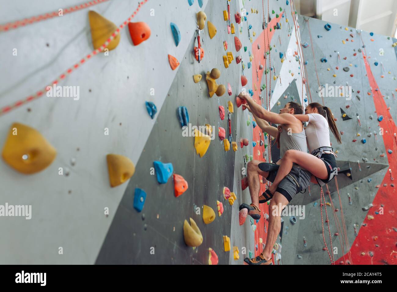 a couple wotking out in an indoor bouldering gym. low angle view. copy  space Stock Photo - Alamy