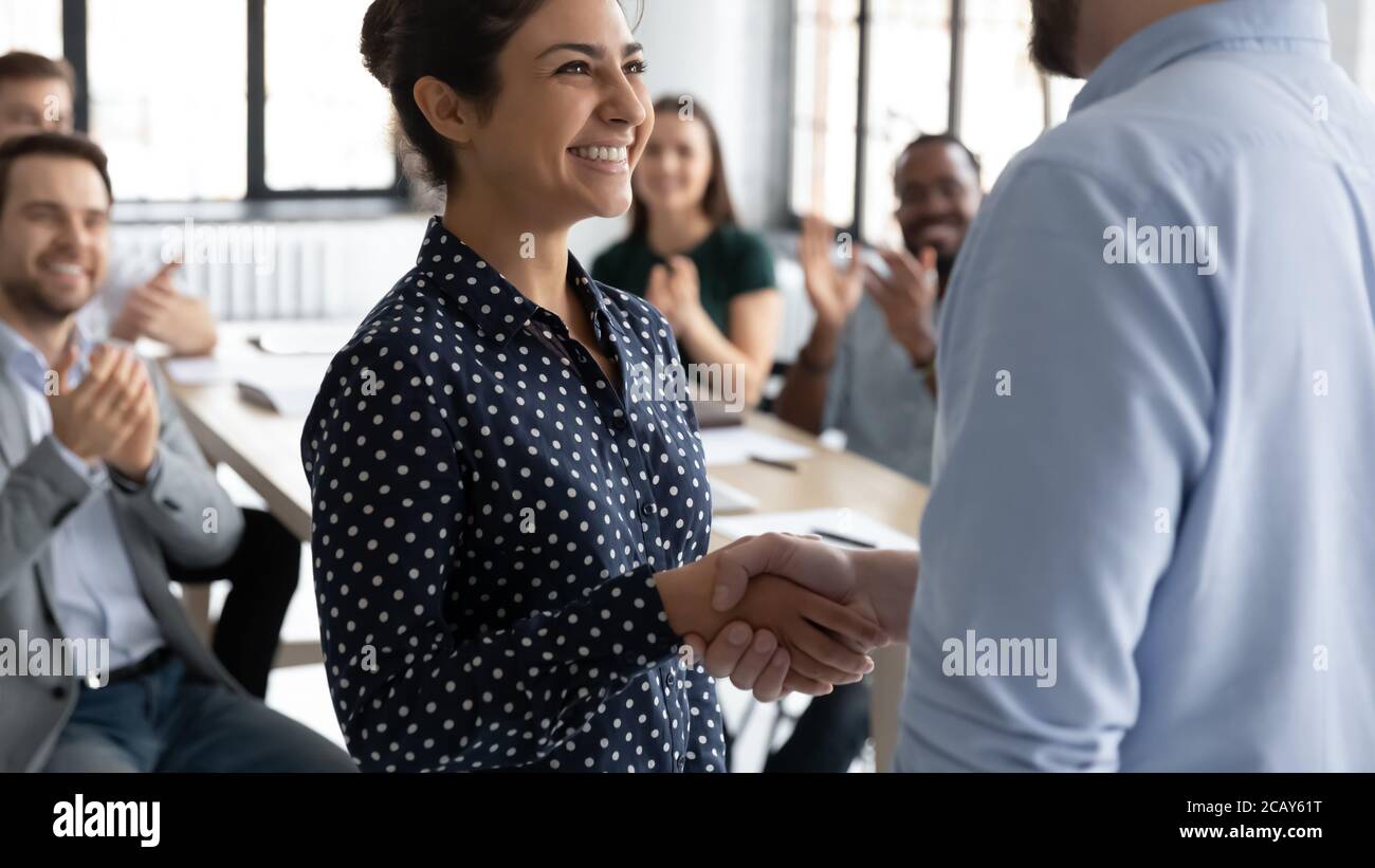 Close up executive shaking smiling Indian businesswoman hand at meeting Stock Photo