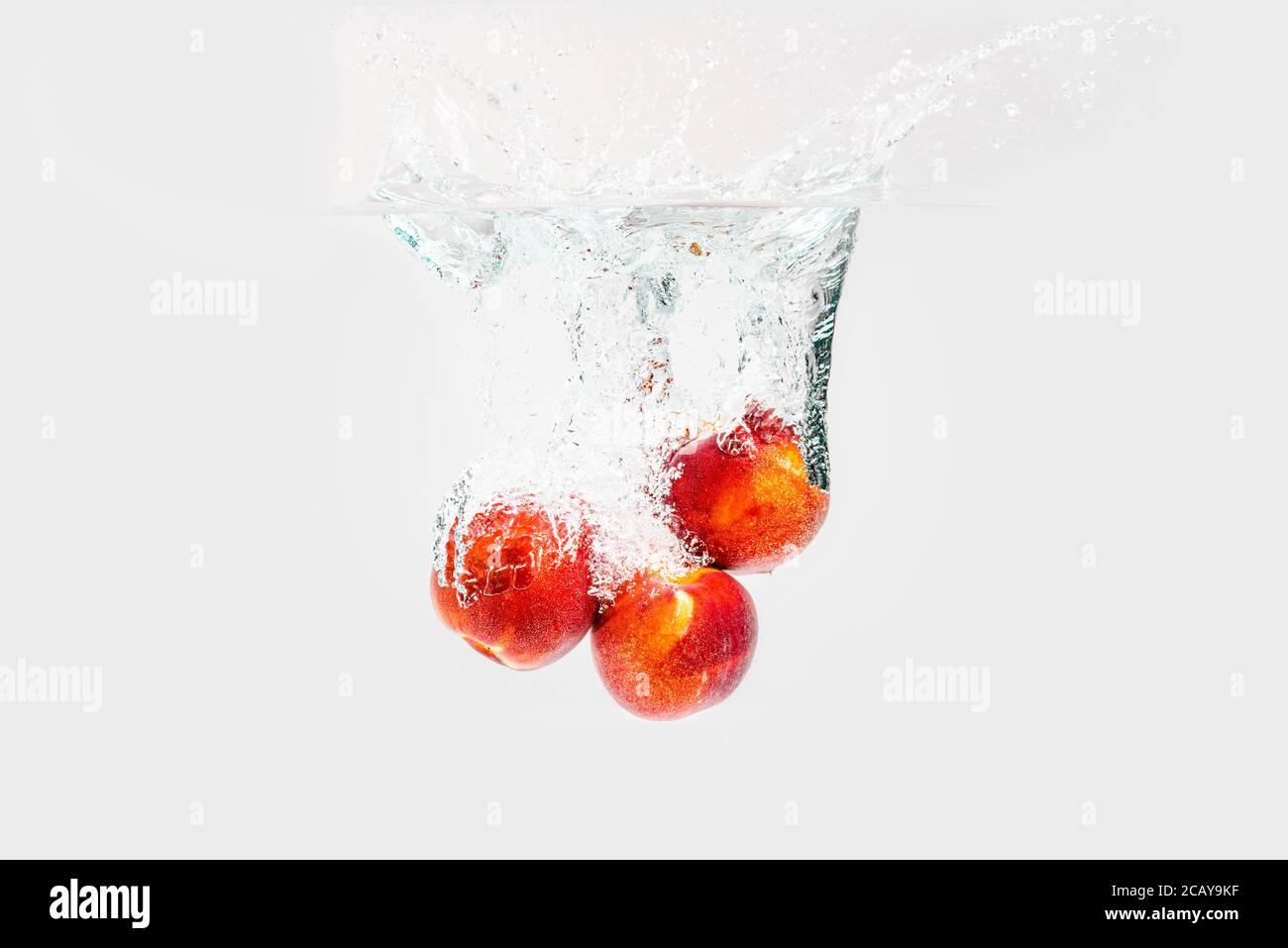 Fresh Nectarines with water splash against white background Stock Photo